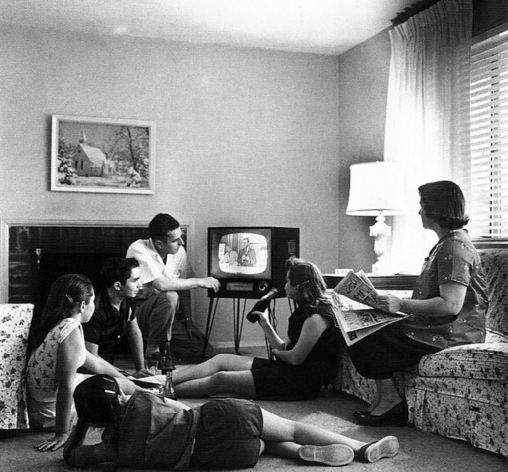 Familia reunida viendo la televisión por la noche